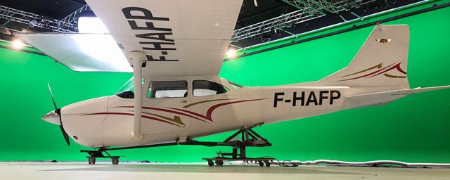 L'avion devant le fond vert où ont été tournées une partie des séquences de DNA.