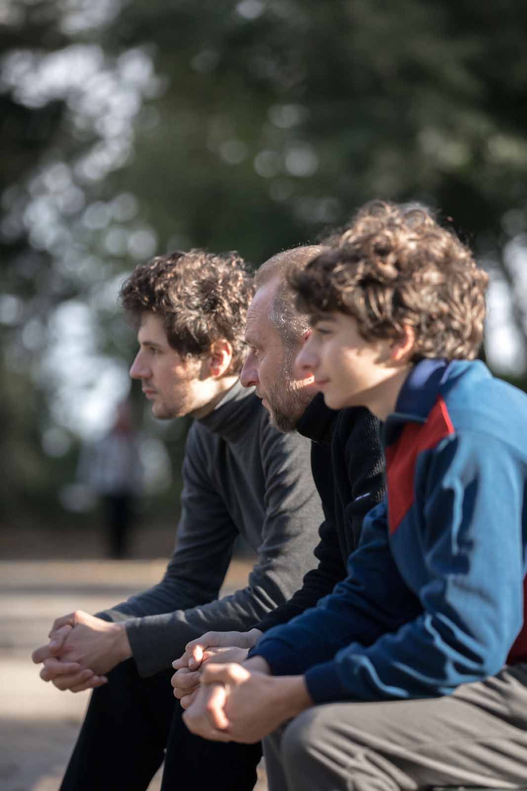 Deux Fils de Félix Moati – Benoît Poelvoorde, Vincent Lacoste et Mathieu Capella assis sur un banc